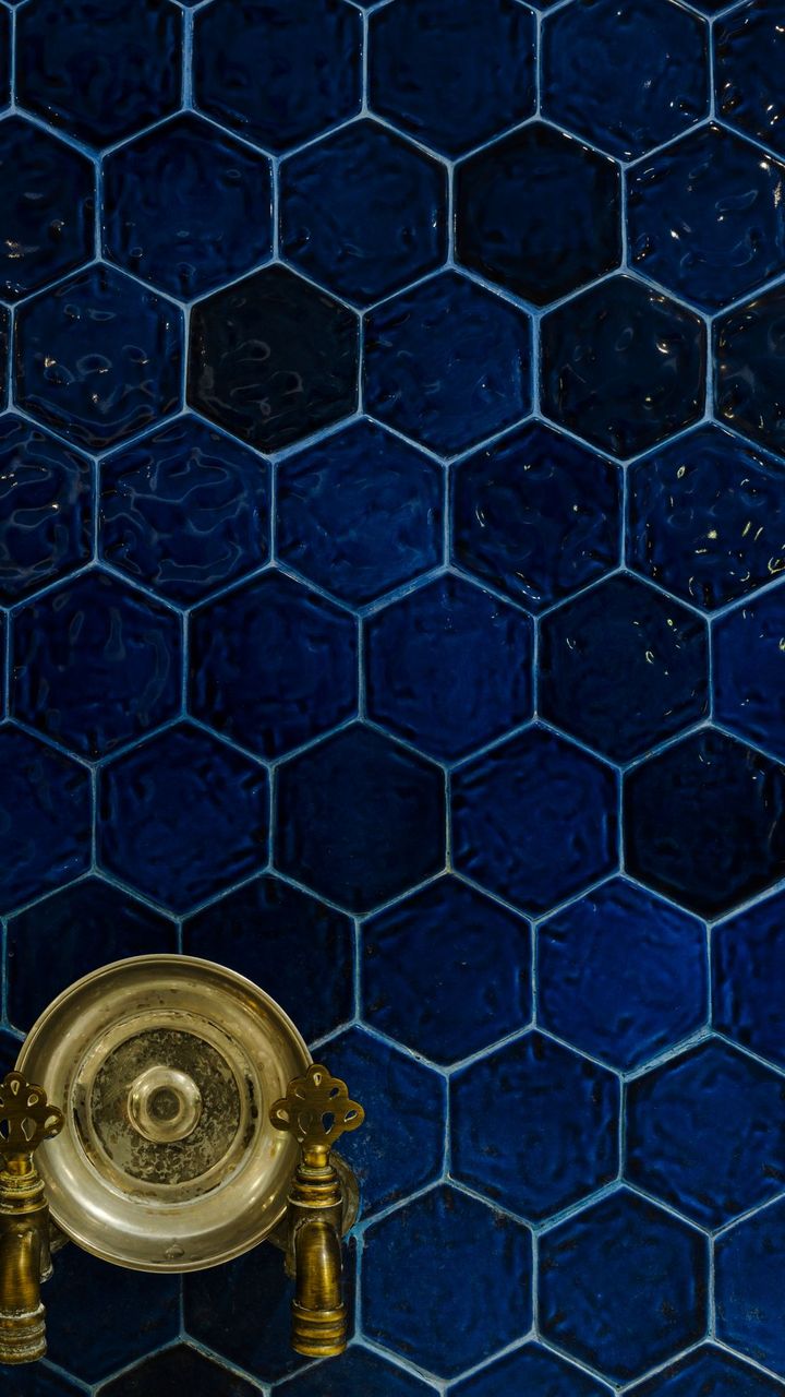Detalhe do revestimento hexagonal azul com registro dourado